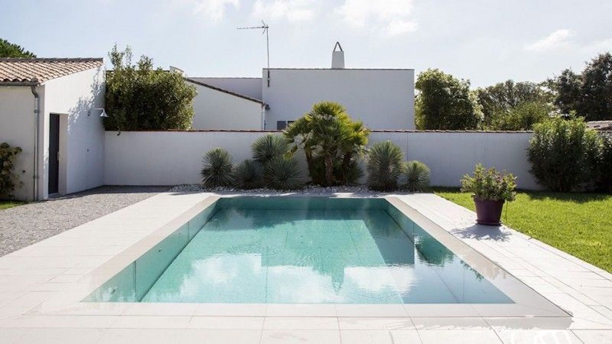 Jolie piscine enterrée avec margelles et terrasse en pierre